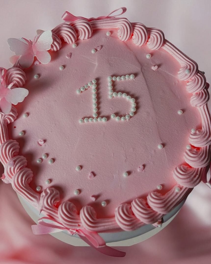 Pastel de quinceañera en rosa palo con lazos y el número 15